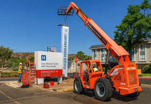 Monument ID sign being installed at a medical center with a reach lift
