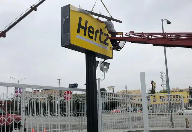 Crane installing a large pole sign at a commercial property